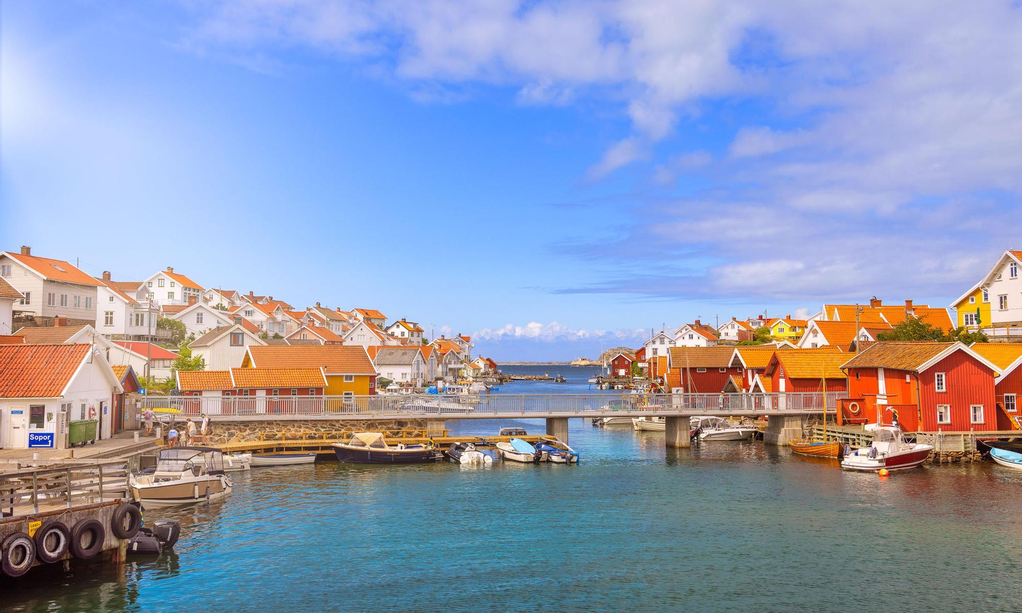 Bohuslänsk skärgårdhamn med vita och röda hus vid hamnen