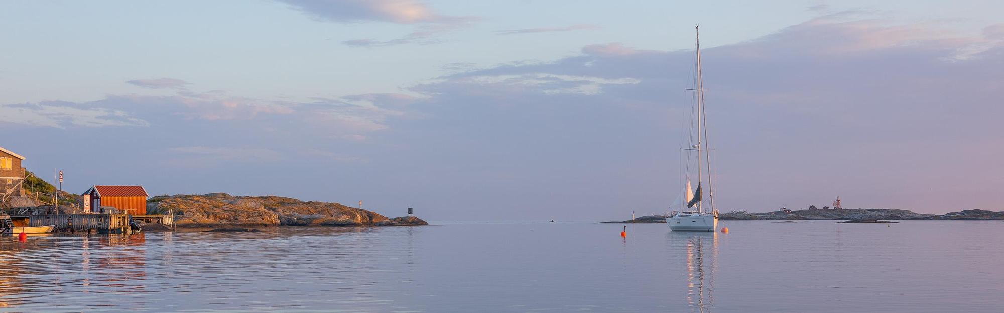 Segelbåt ligger för ankar i vattnet utanför Käringön